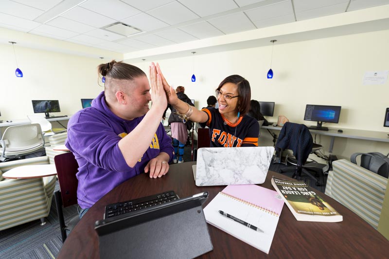 Student and teacher high fiving