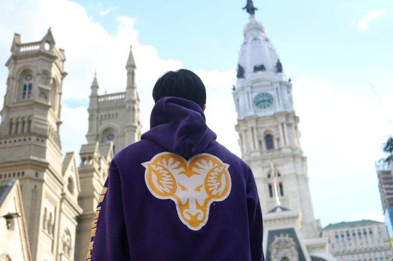 Student in Ram Sweatshirt in front of City Hall