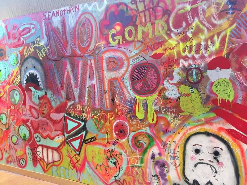 Photo Wall of Grafitti including the words, "Make Art not War." Taken by D Johnson at "The Skate Show"