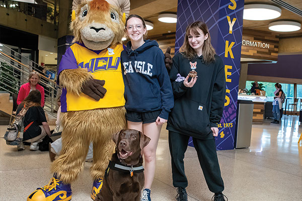 Muddy Puddles (Chocolate lab) poses with rammy and students