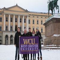 Group of 5 posing with WCU flag (thumbnail)