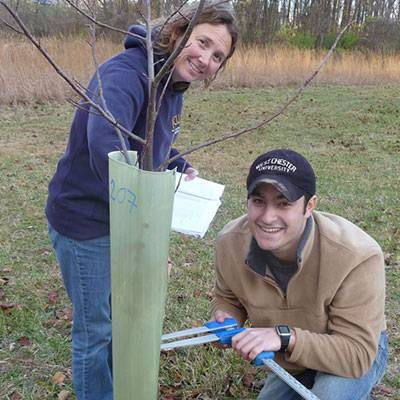 Students Kendra McMillin and Tim Ponticello monitoring the survival and growth of trees planted at the GNA