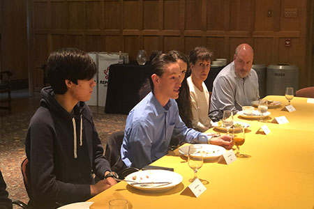 Young men sitting at table conversing