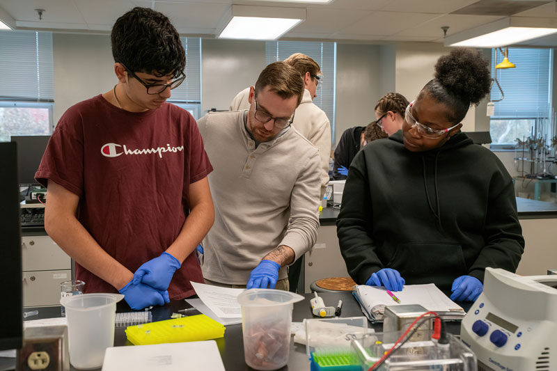 three WCU Chemistry Students working in the Lab on a chemistry project