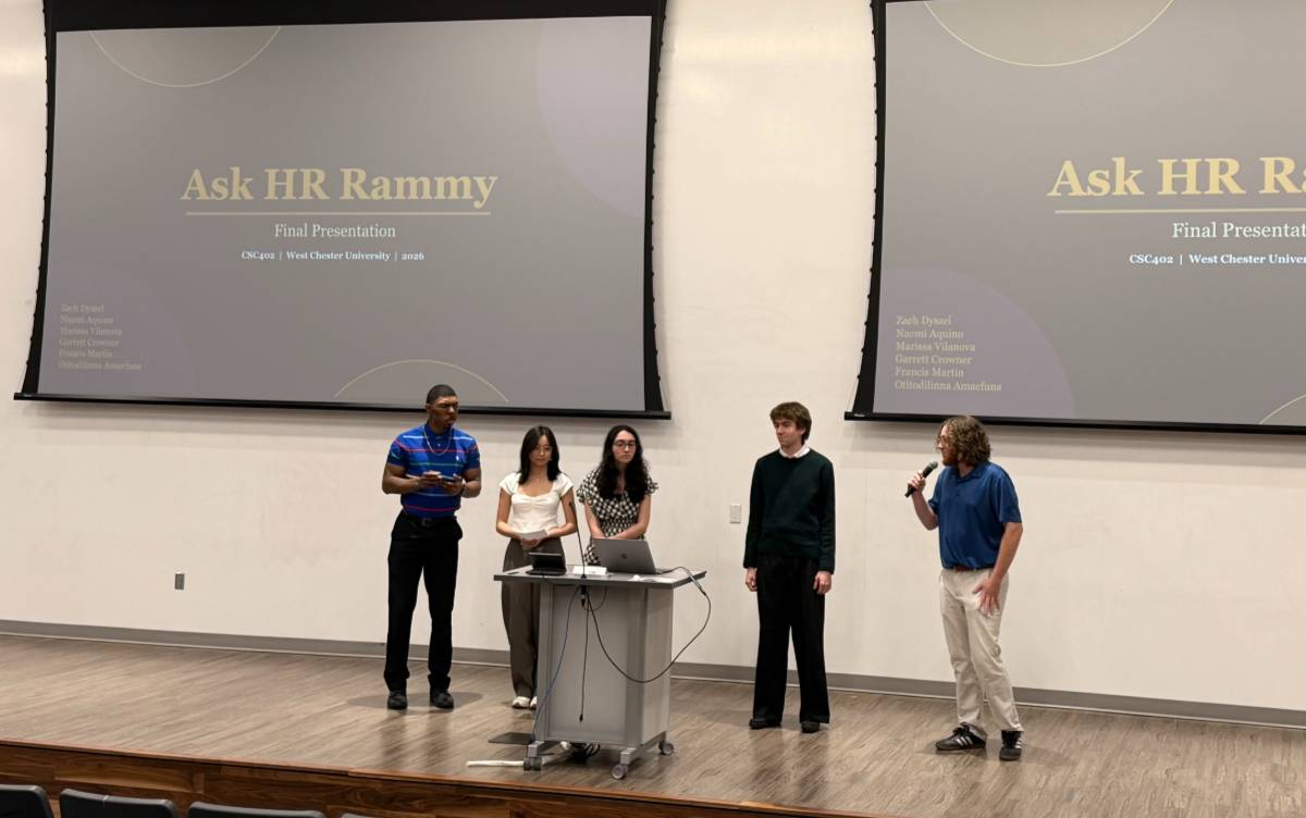 Five students stand on a stage and present their project findings